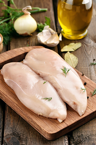 Raw chicken meat on cutting board